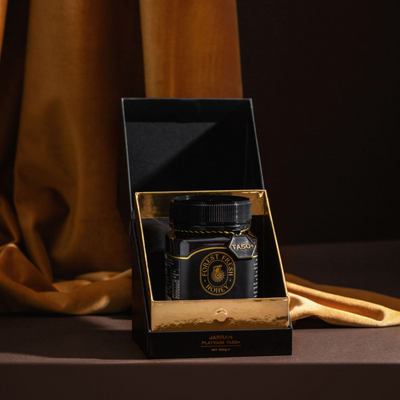 Beautiful black gift box open with gold foiling details, honey and authentication tag